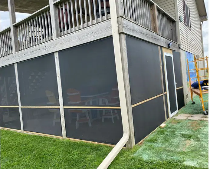 A house with a large screen wall in the back yard.